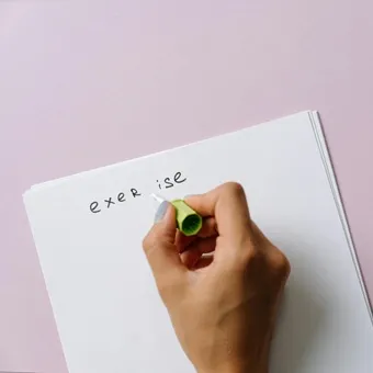 Hand applying correction fluid to writing on a page